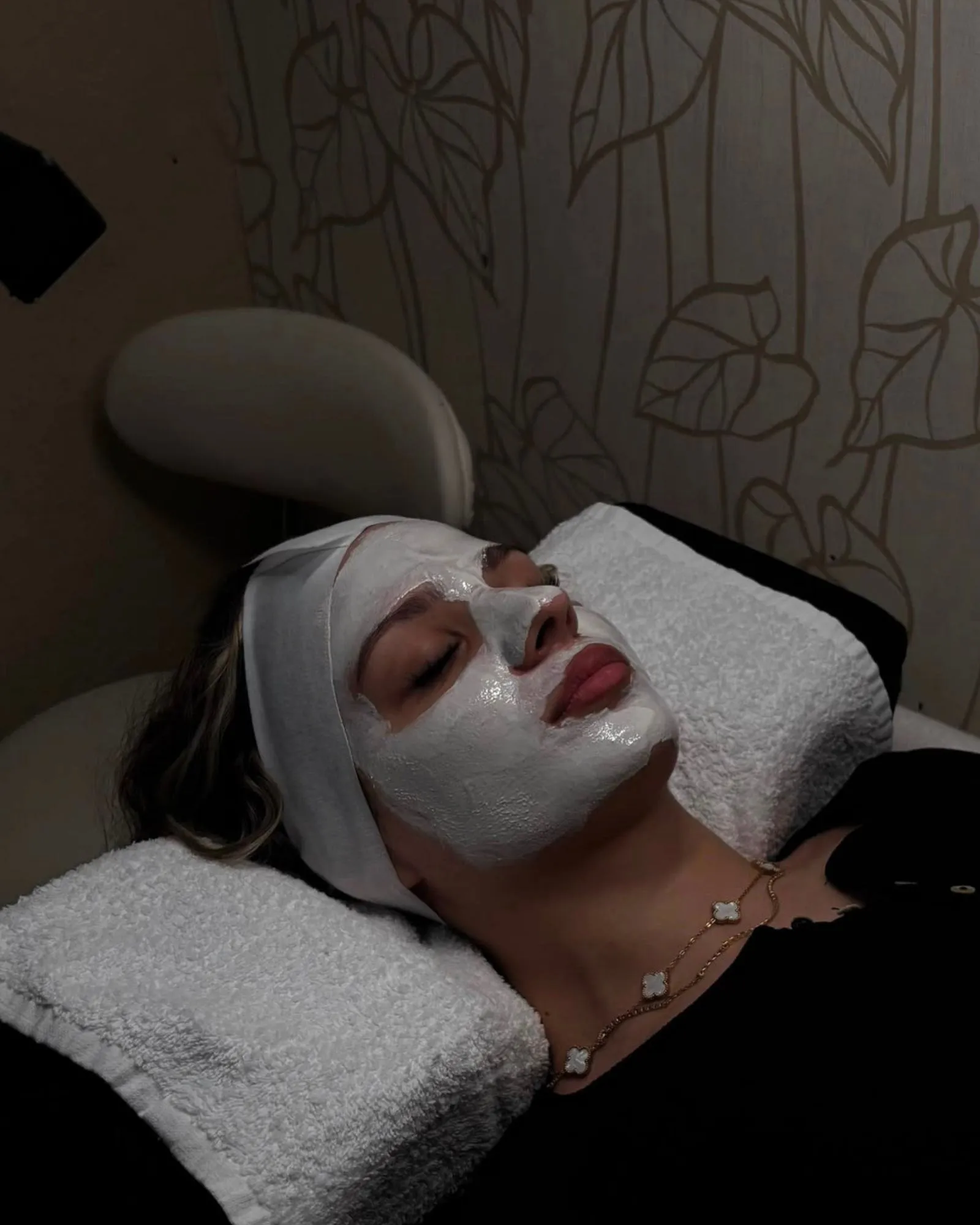 Kundin mit pflegender Gesichtsmaske entspannt bei einer Facial-Behandlung im Studio von SB Sisters Beauty.