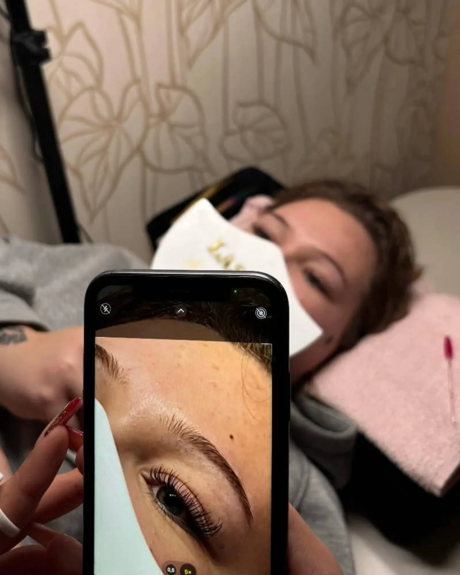Behandlungsmoment im Studio: Das Ergebnis einer Augenbrauen- und Wimpernbehandlung wird per Smartphone festgehalten.