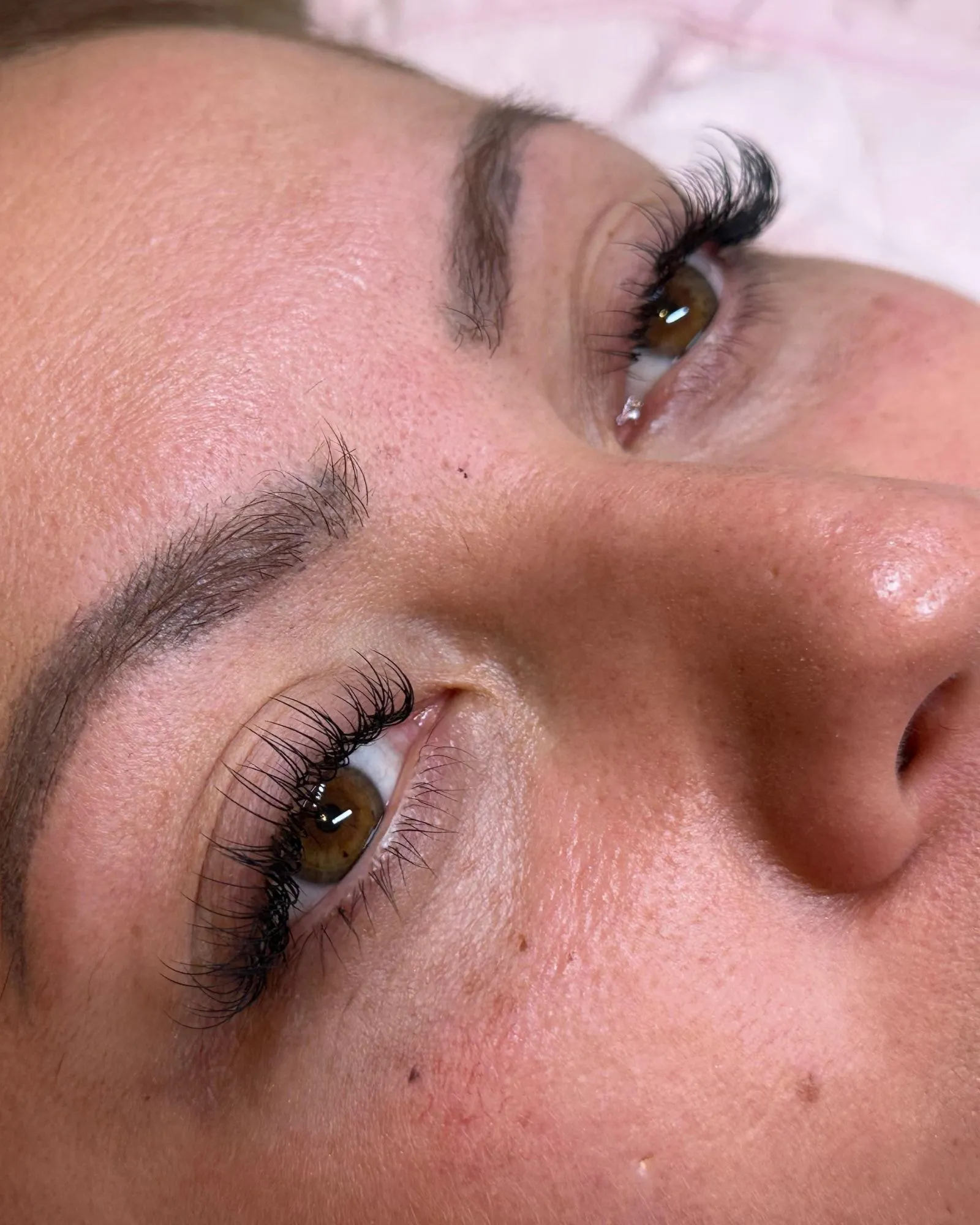 Seitliche Nahaufnahme beider Augen mit natürlich verlängerten Wimpern nach der Behandlung.